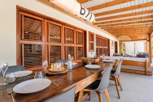 een eetkamer met een grote houten tafel en stoelen bij Villa Tanamera in Grand-Bourg