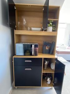 une bibliothèque avec un micro-ondes et un bureau dans l'établissement AnaManô Flat térreo, à São Miguel dos Milagres 5 autres photos