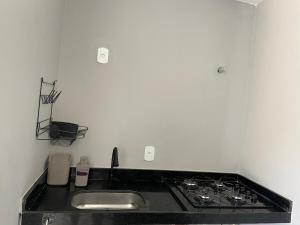 une cuisine avec un évier et une cuisinière dans l'établissement AnaManô Flat térreo, à São Miguel dos Milagres