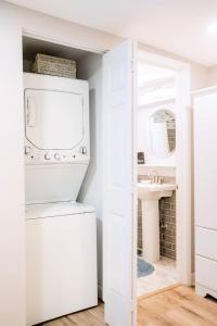 eine weiße Waschküche mit Waschmaschine und Trockner in der Unterkunft Cozy Coastal Cottages of Dunedin 3 in Dunedin