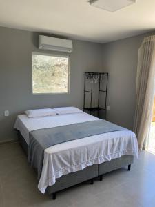une chambre avec un grand lit avec une fenêtre dans l'établissement AnaManô Flat térreo, à São Miguel dos Milagres