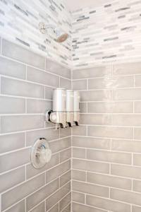 ein Badezimmer mit weiß gefliesten Wänden und weißen Armaturen in der Unterkunft Cozy Coastal Cottages of Dunedin 3 in Dunedin + 35 Fotos