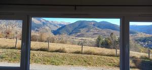 a view of a mountain range from a window at Le panoramique in Saillagouse +2 photos