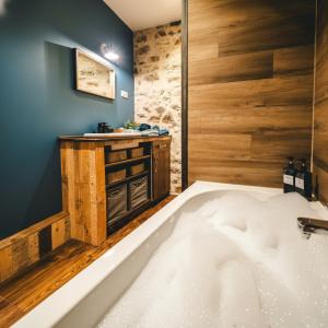 a bath tub in a bathroom with blue walls at L'Atelier - Gîte chaleureux et relaxant in Saint-Hubert +16 photos