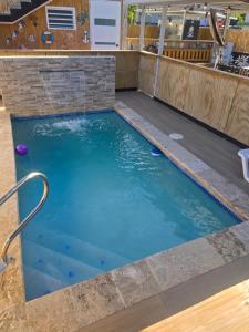 een zwembad met een stenen muur en blauw water bij Villa Mi casita el paraiso costero in Aguada