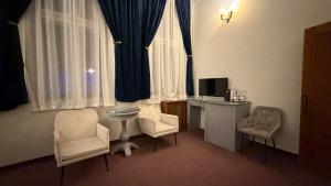 バイレ・ヘルクラネにあるVila Băncii Naționaleの椅子2脚とテーブル1台とテレビがある部屋