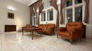 バイレ・ヘルクラネにあるVila Băncii Naționaleの革張りの椅子とテーブルのあるリビングルーム