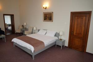 een slaapkamer met een bed en een houten deur bij Vila Băncii Naționale in Băile Herculane