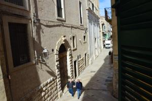 Due persone che camminano per strada in un vicolo di B&B Maison Lunarè ad Altamura Altre 4 foto