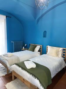 due letti in una stanza con pareti blu di B&B Maison Lunarè ad Altamura