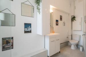 a white bathroom with a toilet and a sink at Beautiful Haussmannian apartment in Mulhouse city center in Mulhouse