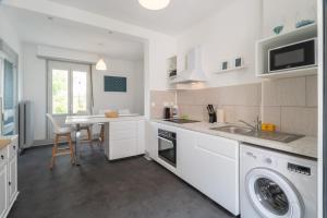 a kitchen with a sink and a washing machine at Beautiful Haussmannian apartment in Mulhouse city center in Mulhouse +17 photos