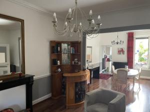 a living room with a chandelier and a dining room at Le Magnolia Vichy in Vichy