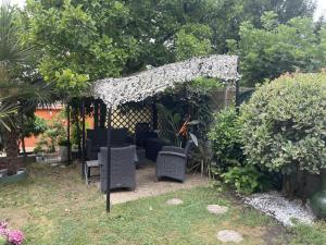 a pergola in a yard with chairs and trees at Le Magnolia Vichy in Vichy