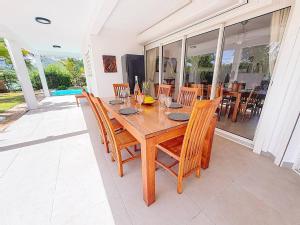 ein Esszimmer mit einem Holztisch und Stühlen in der Unterkunft Villa La Note Bleue in Cul de Sac