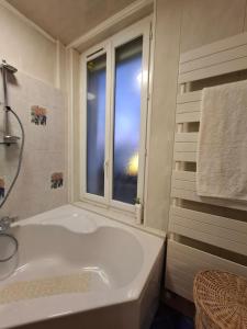 a white bathroom with a tub and a window at Le Magnolia Vichy in Vichy +7 photos