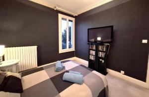 a bedroom with a bed and a television in it at Le Magnolia Vichy in Vichy