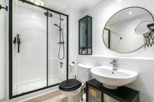 une salle de bain avec un lavabo, des toilettes et un miroir dans l'établissement Charming Central Studio with Balcony in Birmingham, à Birmingham