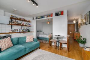 un salon avec un canapé bleu et une table dans l'établissement Charming Central Studio with Balcony in Birmingham, à Birmingham