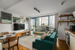 un salon avec un canapé vert et une table dans l'établissement Charming Central Studio with Balcony in Birmingham, à Birmingham 4 autres photos