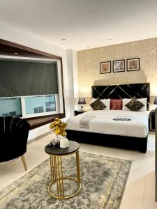 Un dormitorio con una cama grande y una mesa. en Penta Square Signature Hotel Apartments - DHA Phase 5 Lahore, en Lahore