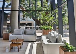 a lobby with couches and a table and some plants at Cozy apartment with fantastic gym and pool in Asuncion