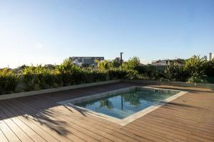 a swimming pool on top of a wooden deck at Cozy apartment with fantastic gym and pool in Asuncion