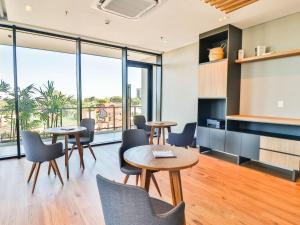 a meeting room with tables and chairs and windows at Cozy apartment with fantastic gym and pool in Asuncion