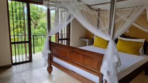 a bedroom with a canopy bed with yellow pillows at Welpalla Signature 