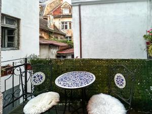 ein Tisch und Stühle auf einem Balkon in der Unterkunft Ada Old Town 7 in Braşov