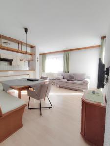 een woonkamer met een tafel en een bank bij das Alpenblick & Outdoor Lodge Nauders in Nauders