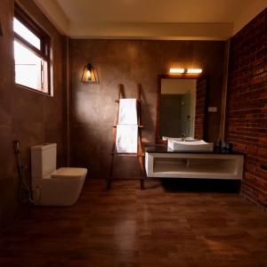 a bathroom with a sink and a toilet and a mirror at Welpalla Signature 
