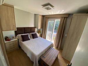 ein Schlafzimmer mit großem Bett und Fenster in der Unterkunft Casa Tranquila - Condomínio Vila Verde Canela in Canela