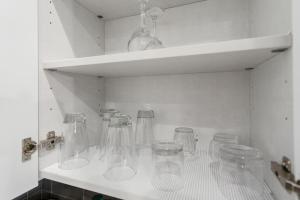 a row of glass jars sitting on a shelf at JoyFull 2BD In the Heart of Magnolia in Fort Worth +36 photos