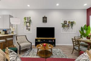 a living room with a tv and a table at The Quartz 2BD Townhouse in the heart of FW in Fort Worth