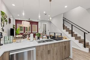 a kitchen with a sink and a staircase at The Quartz 2BD Townhouse in the heart of FW in Fort Worth