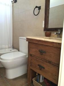 ein Badezimmer mit Toilette, Waschbecken und Spiegel in der Unterkunft Nomeolvides Ocean Park Casa in Ocean Park + 41 Fotos