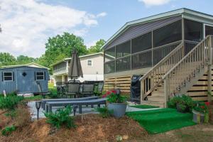 een huis met een terras en een patio met een bankje bij Lake Daze Landing in Greer