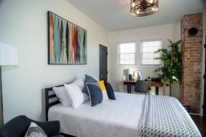 een slaapkamer met een bed met kussens en een bureau bij Pink Door Cottage in Greer