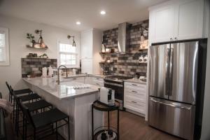 een keuken met een roestvrijstalen koelkast en witte kasten bij Pink Door Cottage in Greer