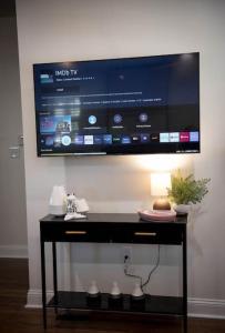 een flatscreen-tv die aan de muur hangt bij Pink Door Cottage in Greer