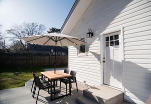 een tafel en stoelen met een parasol op een terras bij Pink Door Cottage in Greer