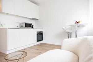 a white kitchen with a couch and a microwave at The Mini Minimalist Free Parking in Lausanne
