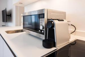 The Mini Minimalist Free Parking في Pully: وجود ميكروويف في الأعلى على منضدة +7 صور