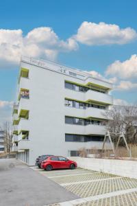 The Mini Minimalist Free Parking في Pully: سيارة حمراء متوقفة أمام مبنى