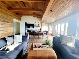 a living room with a blue couch and a table at Enetai Beach House with dock and Hot Tub in Point White