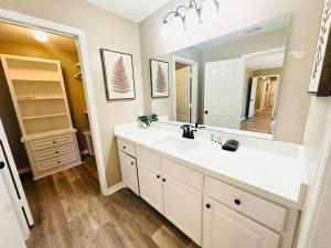 ein Badezimmer mit Waschbecken und großem Spiegel in der Unterkunft Eastgate 18B beautiful townhouse in Hammond + 52 Fotos