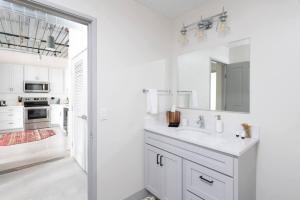 Un baño blanco con lavabo y espejo. en Chic Double Queen Apt Walking Distance to Fiserv, en Milwaukee 17 fotos más