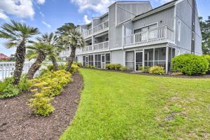 a large gray building with palm trees and a yard at Baytree Golf Colony Studio about 5 Mi to Beach! in Little River