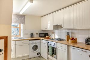 a kitchen with white cabinets and a washer and dryer at 2 Bed in Whitwell oc-r33497 in Whitwell
